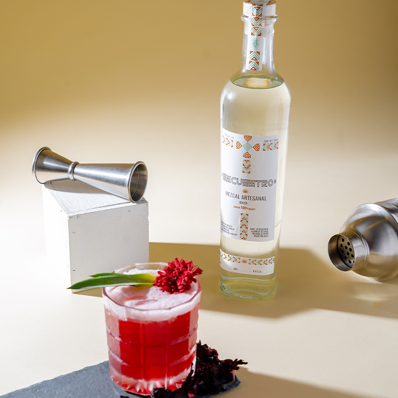 Coctelería con mezcal con frutos rojos, miel de agave, menta y jugo de naranja